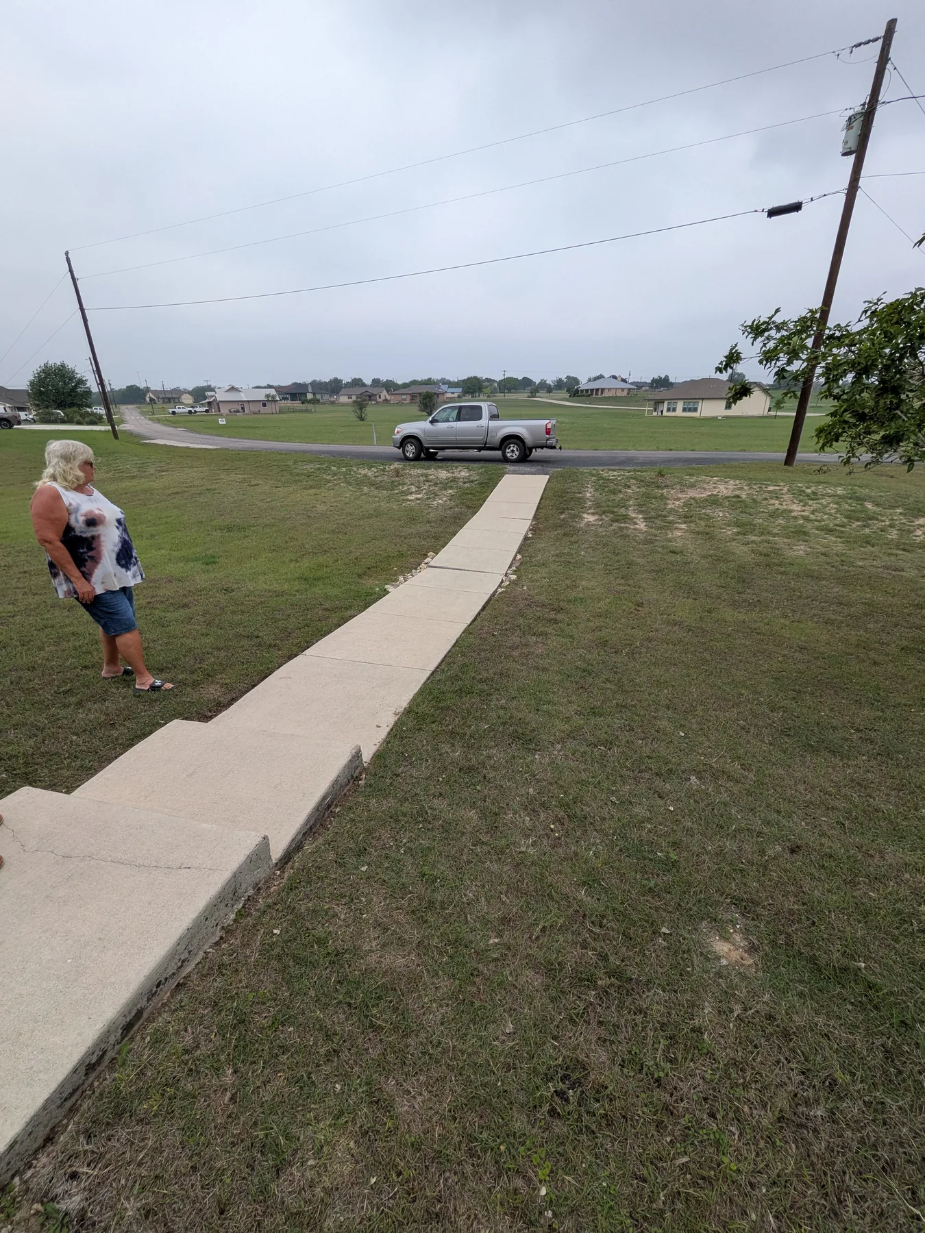 Low front yard drainage area and sidewalk before raised boardwalk construction