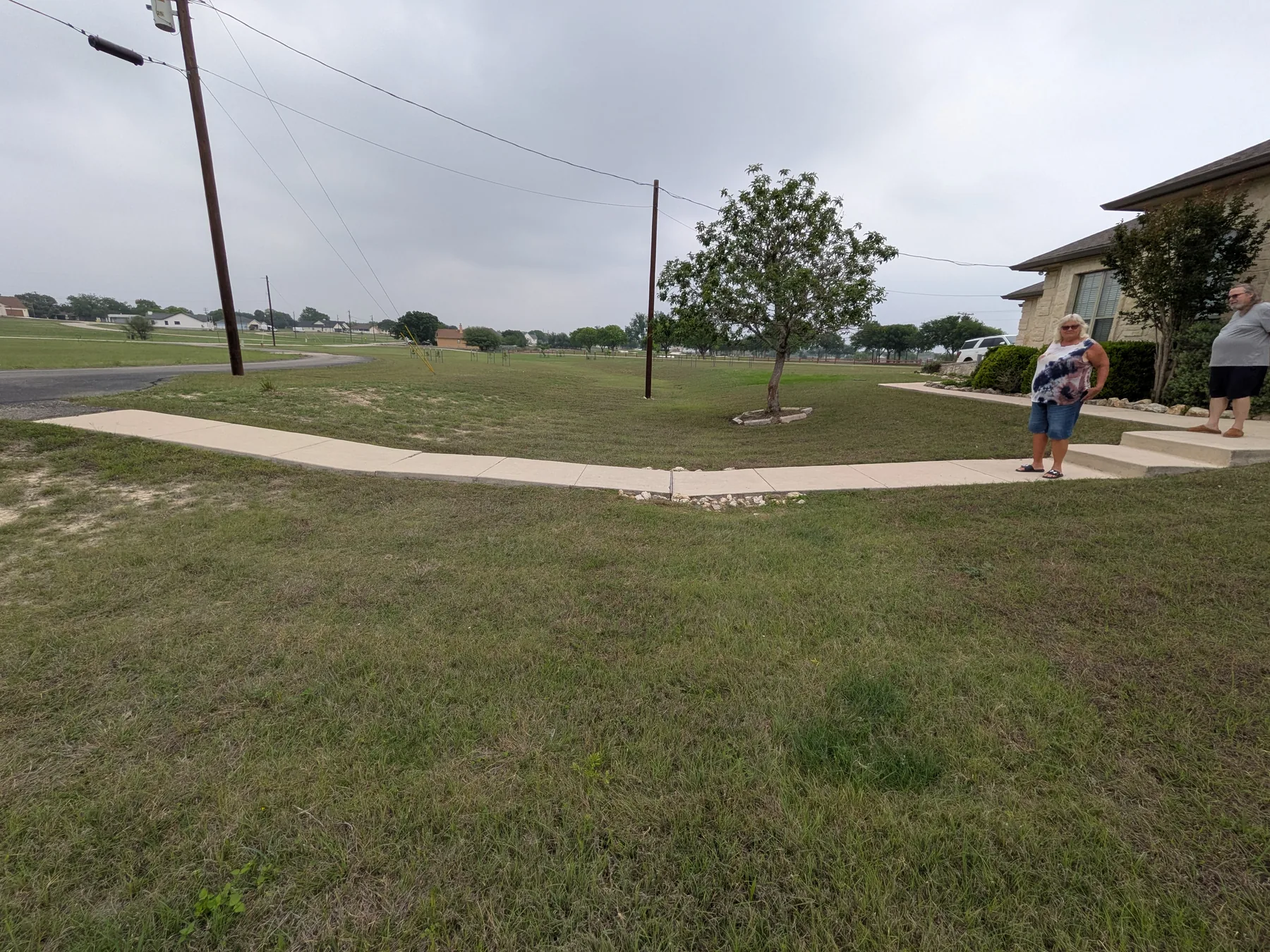 Existing concrete sidewalk crossing the low drainage area before the raised boardwalk was built