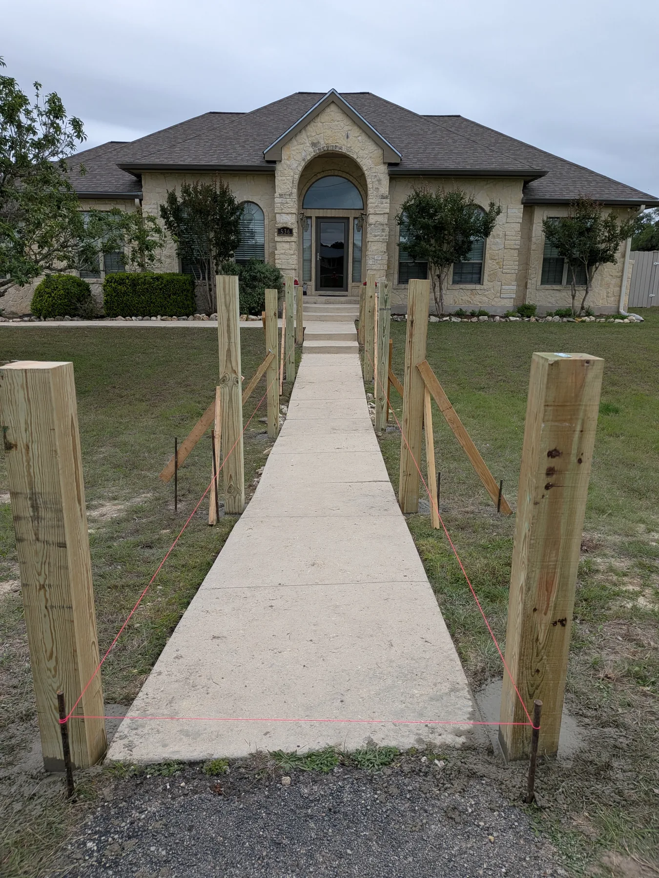 Treated posts set along the existing sidewalk before boardwalk framing