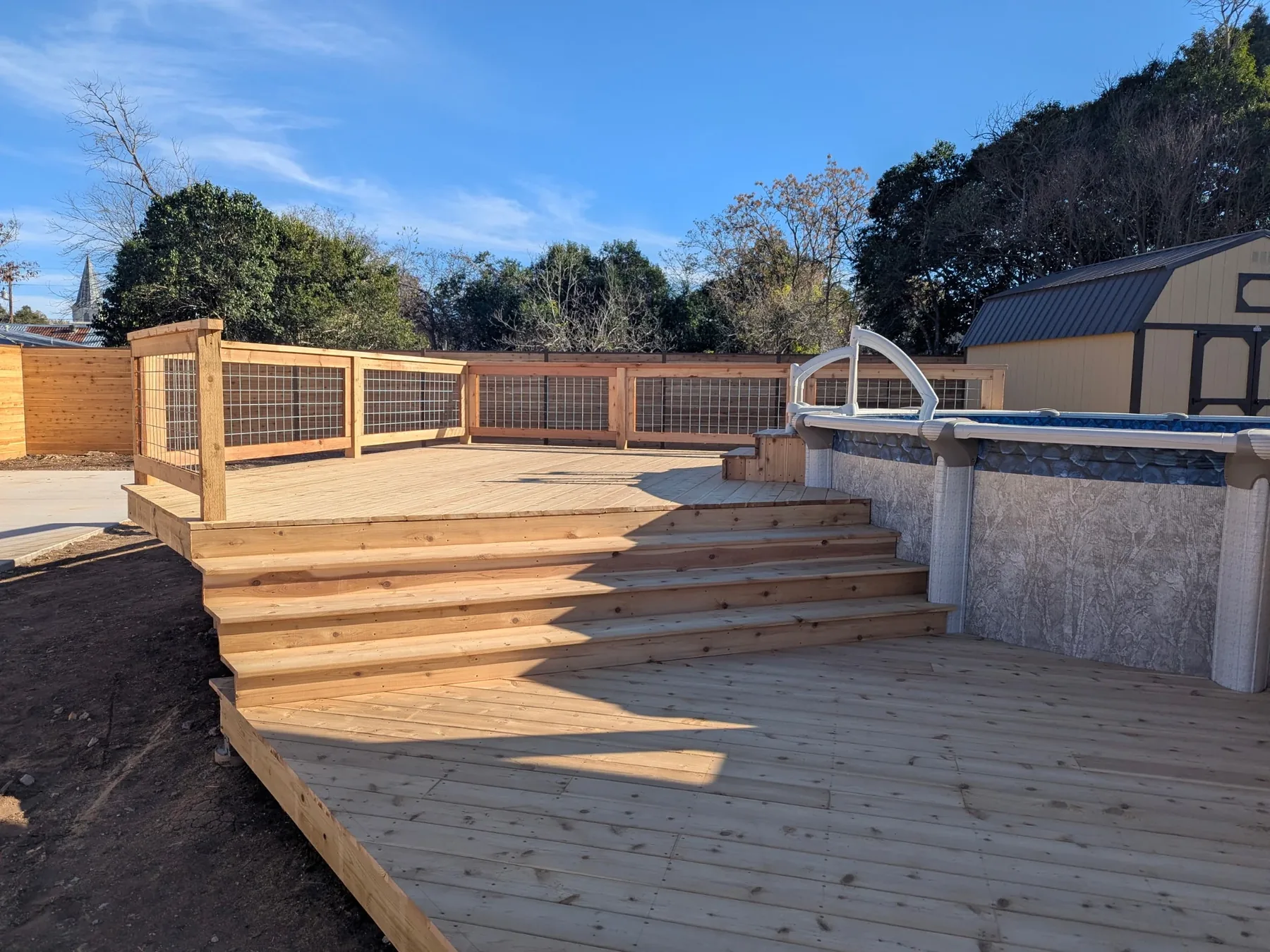 Cedar pool deck before stain with stairs and upper pool access area