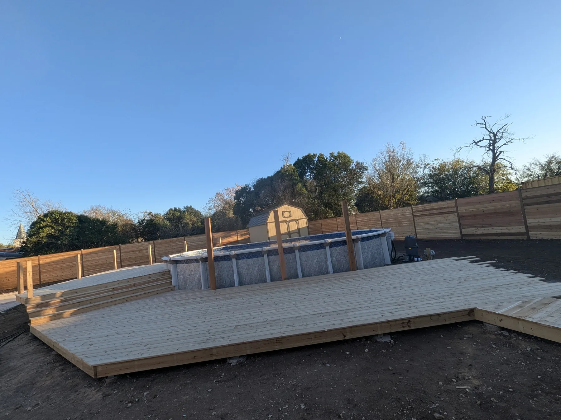 Cedar deck boards installed over the new pool deck framing during construction