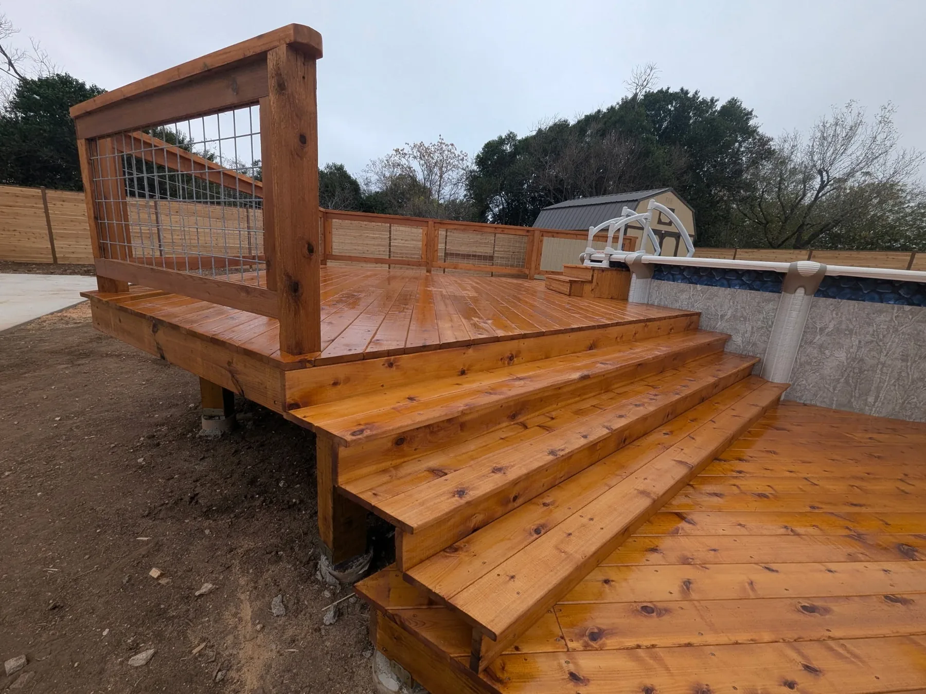Finished cedar stairs and cattle panel railing leading to upper pool deck