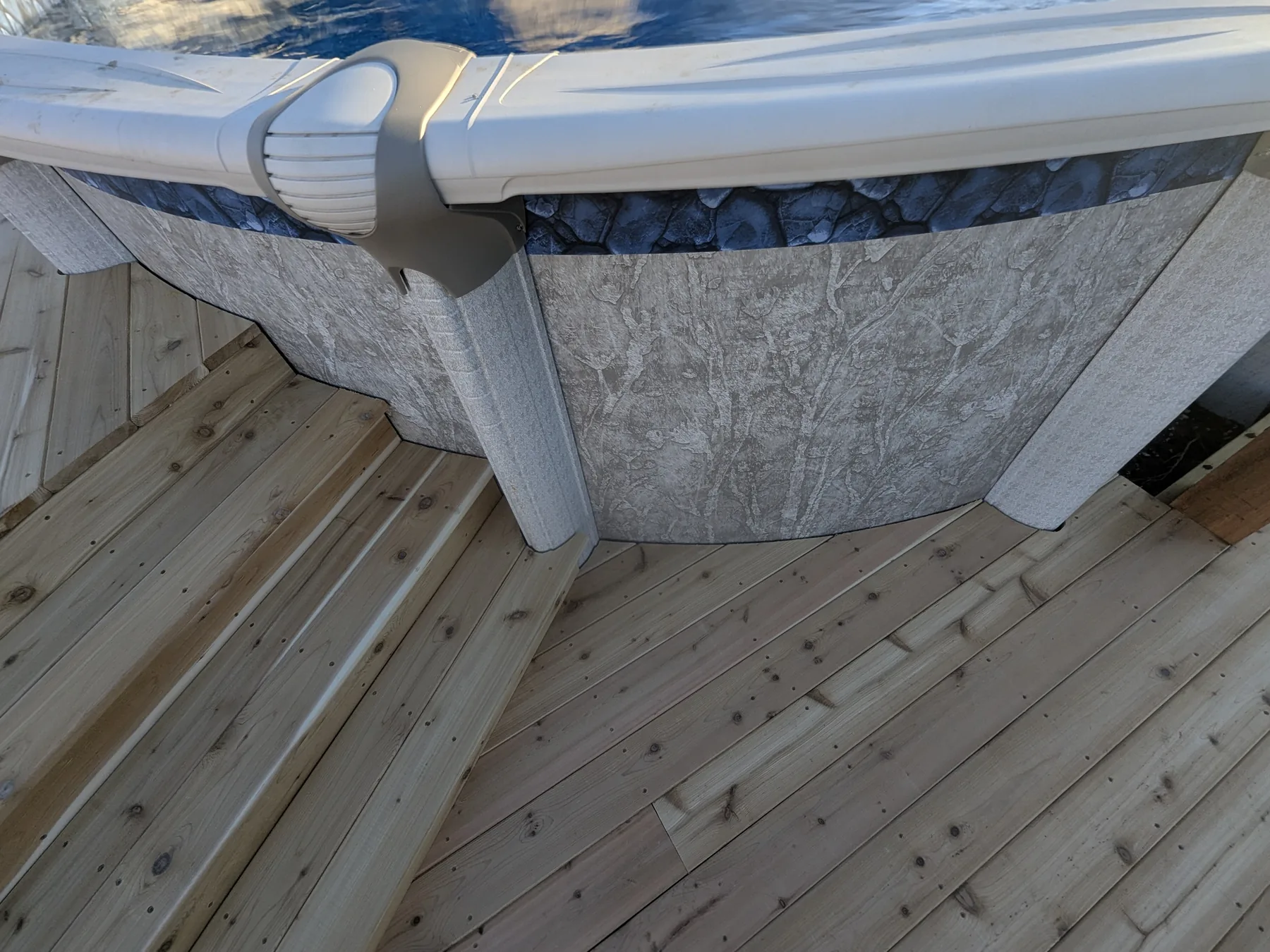Close-up of tight cedar deck board cuts around complex pool edge angles