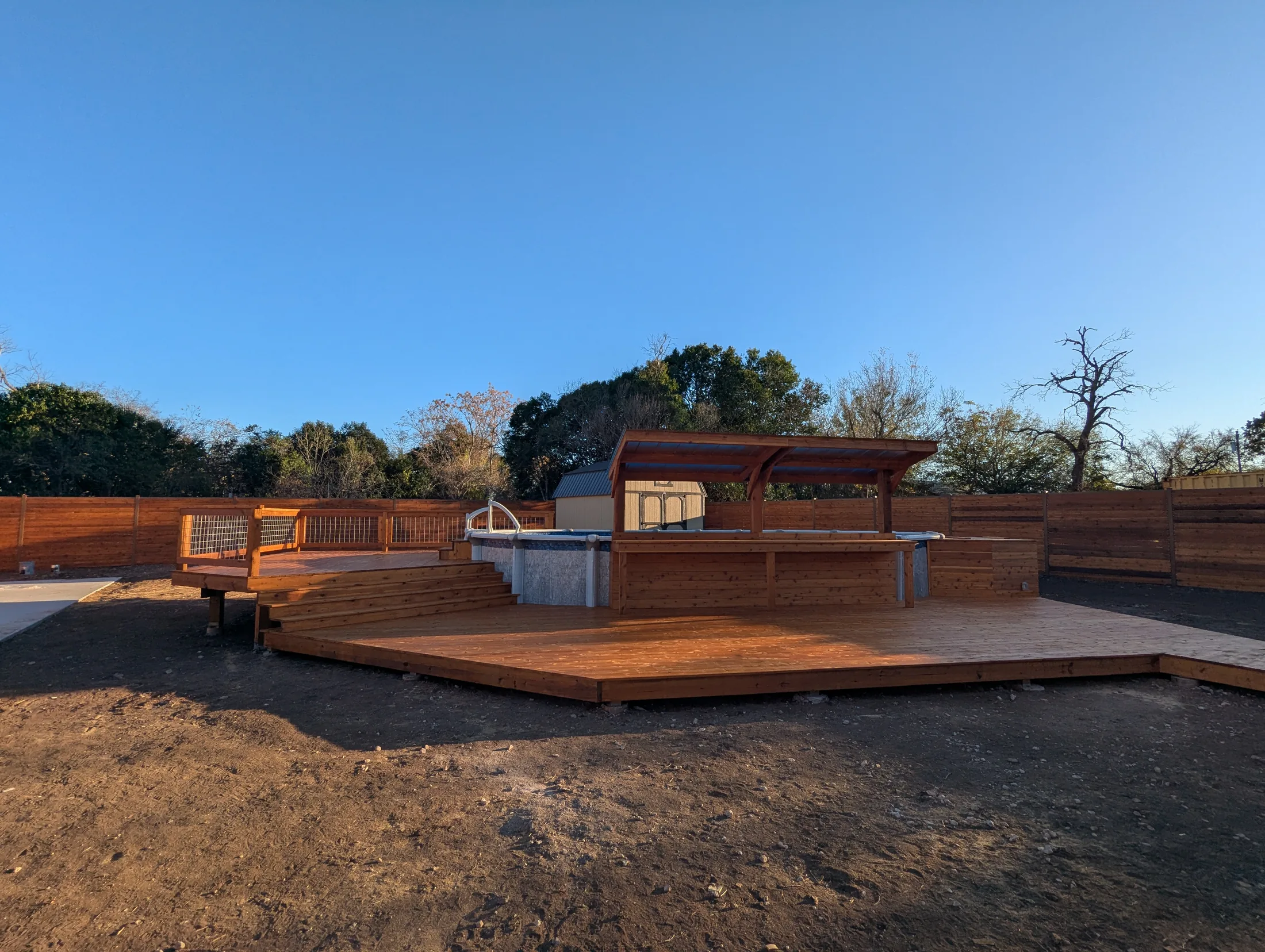 Finished cedar pool deck with covered bar and above-ground pool
