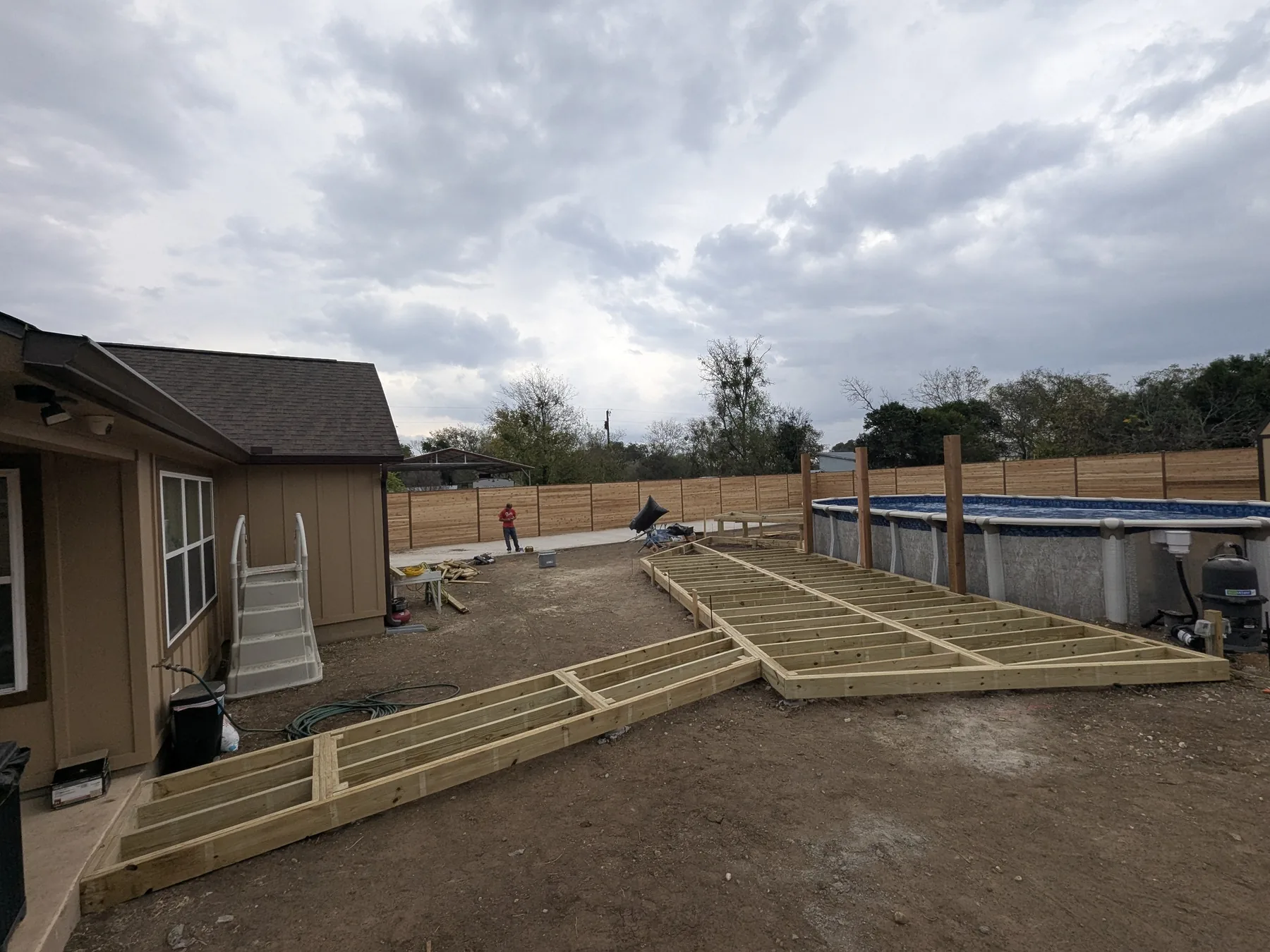 Pressure-treated framing for a large two-tier cedar pool deck around an above-ground pool