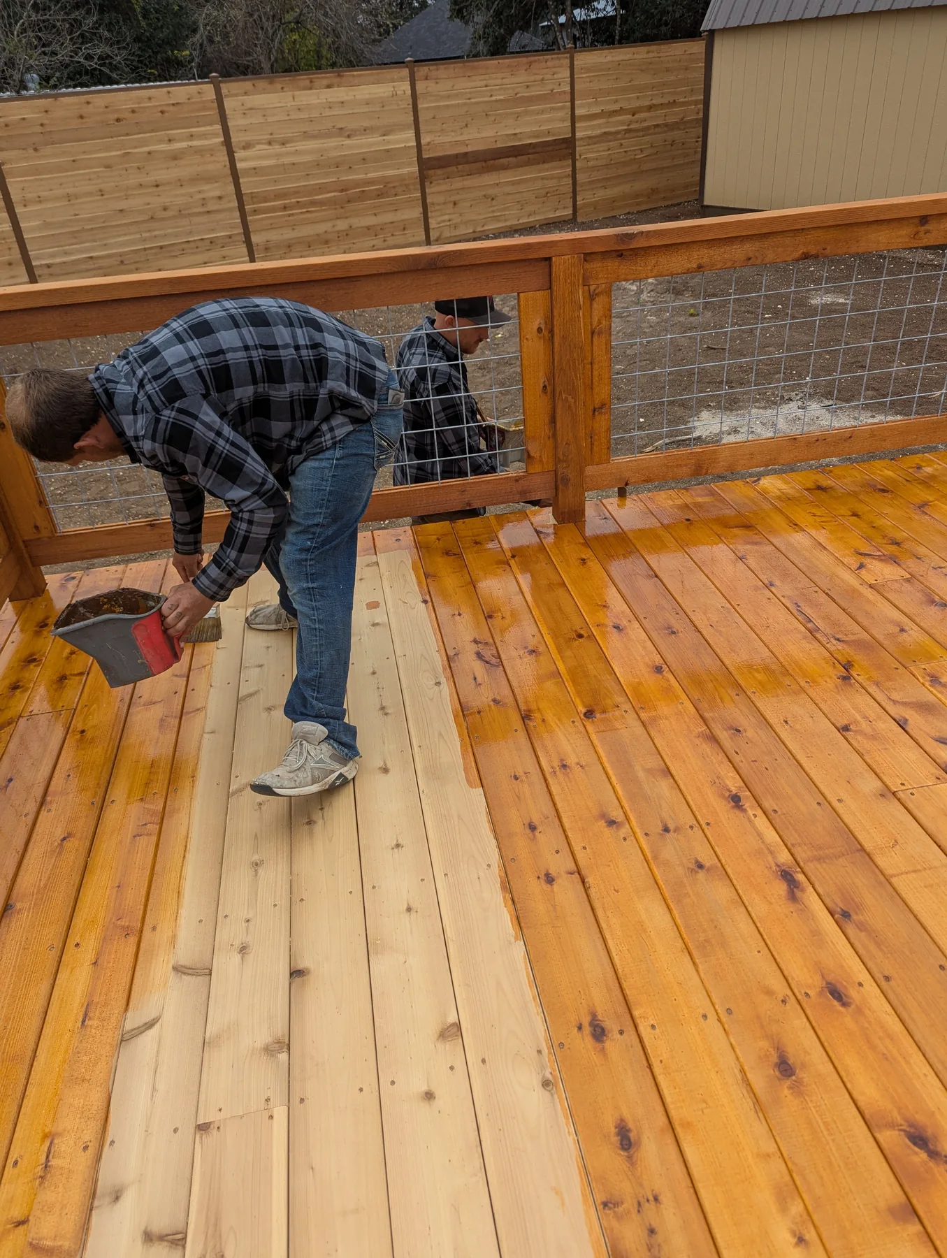 Reddy Pros crew staining cedar deck boards