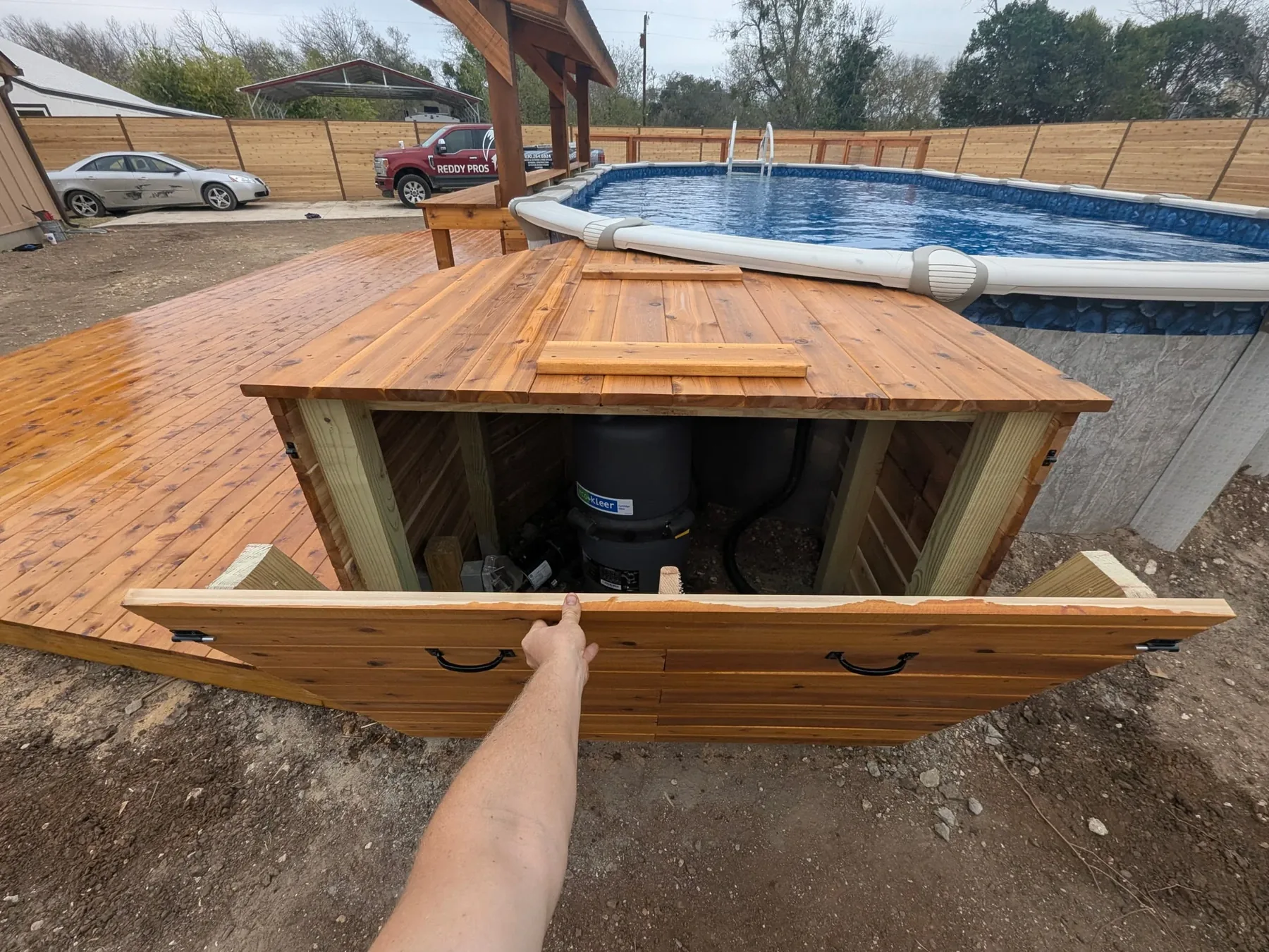 Cedar pool equipment cover open with hinged access and hydraulic supports