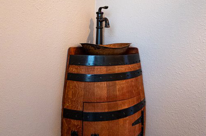 Custom bathroom vanity made from a wiskey barrel and copper sink.