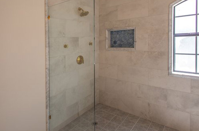 Grey and Gold tile shower with fixtures.